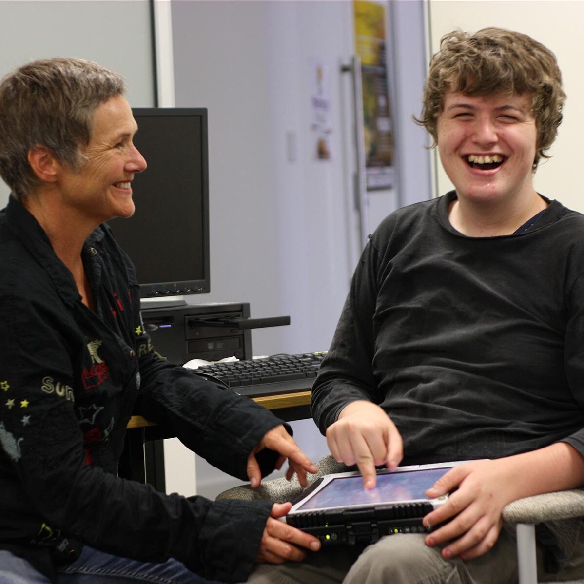 Eli and Gill in an office laughing