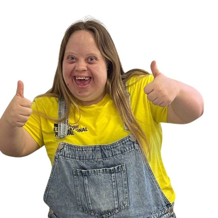 Young adult smiling with her thumbs up