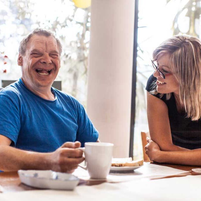 Adult man with down syndrome and a caregiver