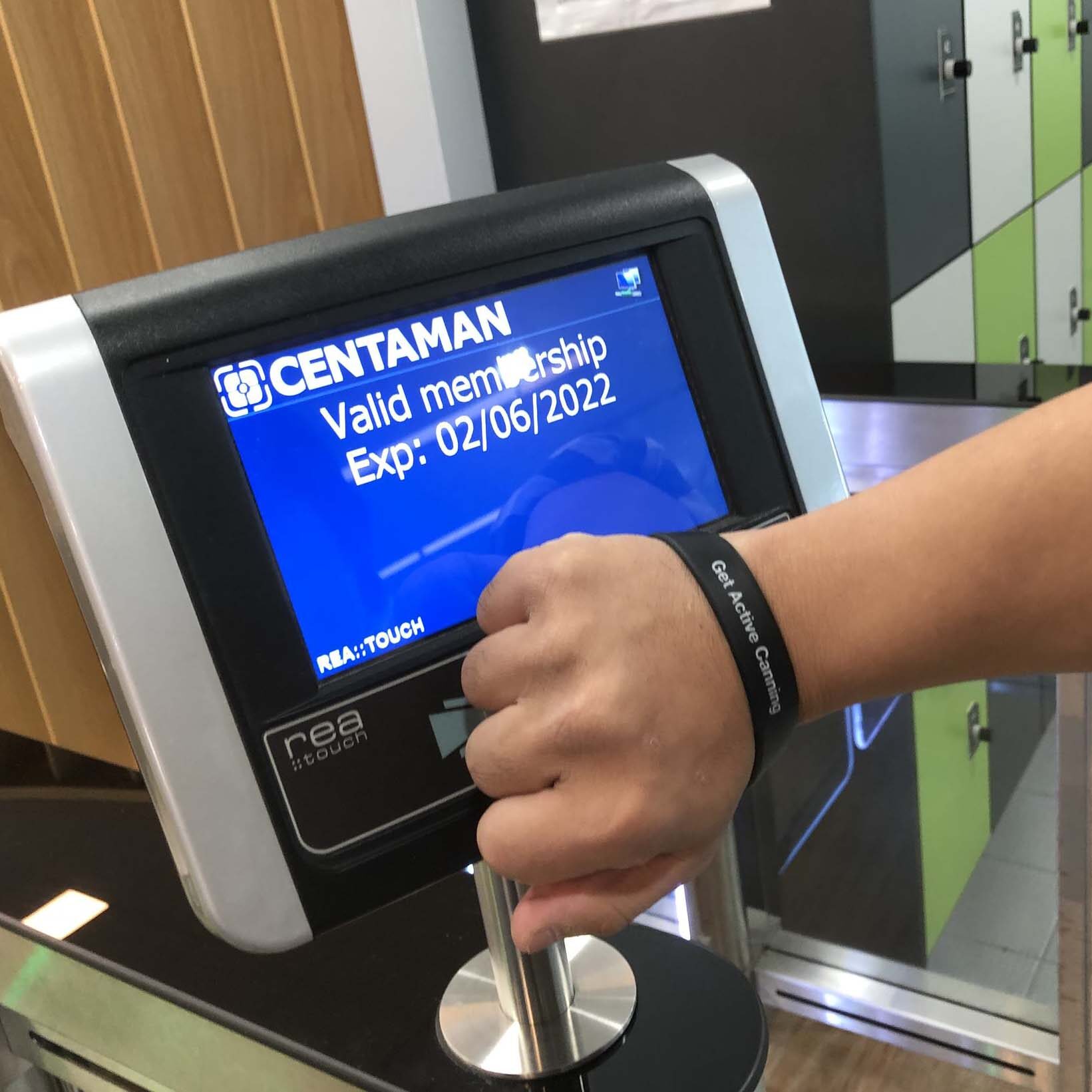 picture of someone tagging on with their membership bracelet to enter the gym