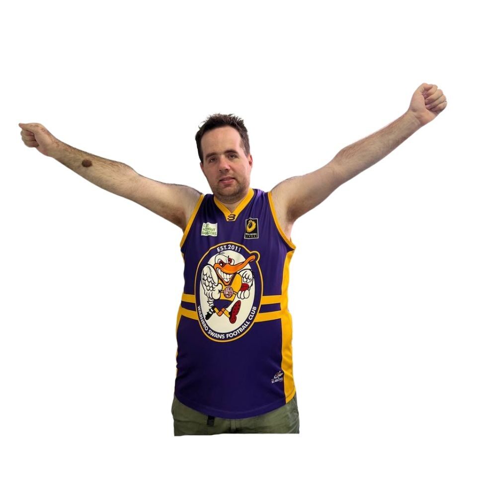 person wearing a sports top with thier arms above their head cheering for thier team